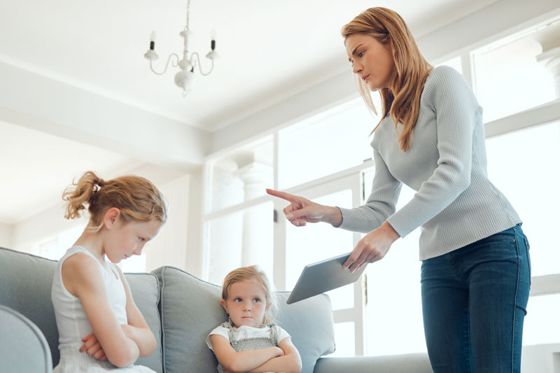 Mother scolding two sad daughters, a subtle sign of bad parenting