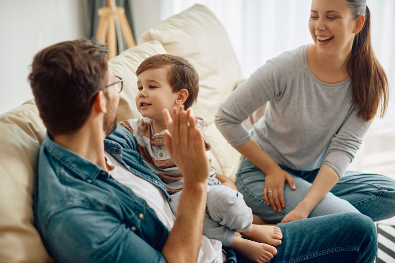 Happy parents bonding with their child, modeling positive parenting after bad patterns