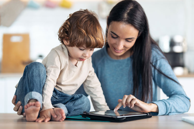 Parent guiding child to use tablet wisely for digital literacy