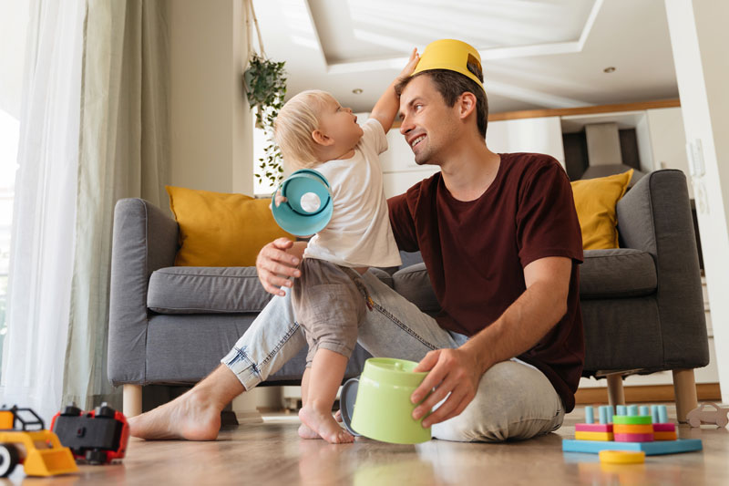 Father bonding with toddler through play at home, showing gentle parenting discipline examples in daily life.